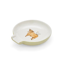 A round off-white ceramic dish with a small handle on the left side, featuring a hand-painted illustration of a brown cow and a white bird in the center, set against a plain white background.