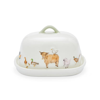 A white ceramic butter dish with a matching lid, decorated with a whimsical illustration of farm animals including a Highland cow, duck, goose, chicken, and pig. The lid features a light sage green handle.