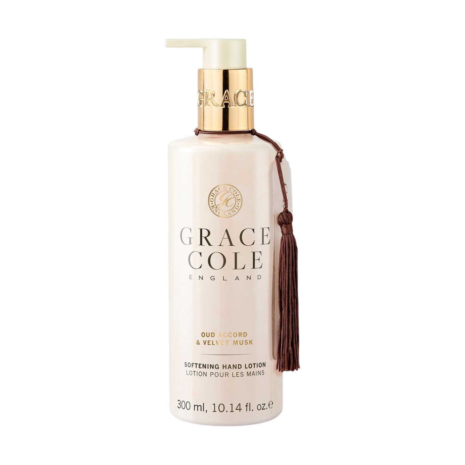 Grace Cole Oud Accord & Amber Hand Lotion 300ml in a clear pump bottle with a gold dispenser and decorative tassel, enriched with shea butter to moisturise dry hands.