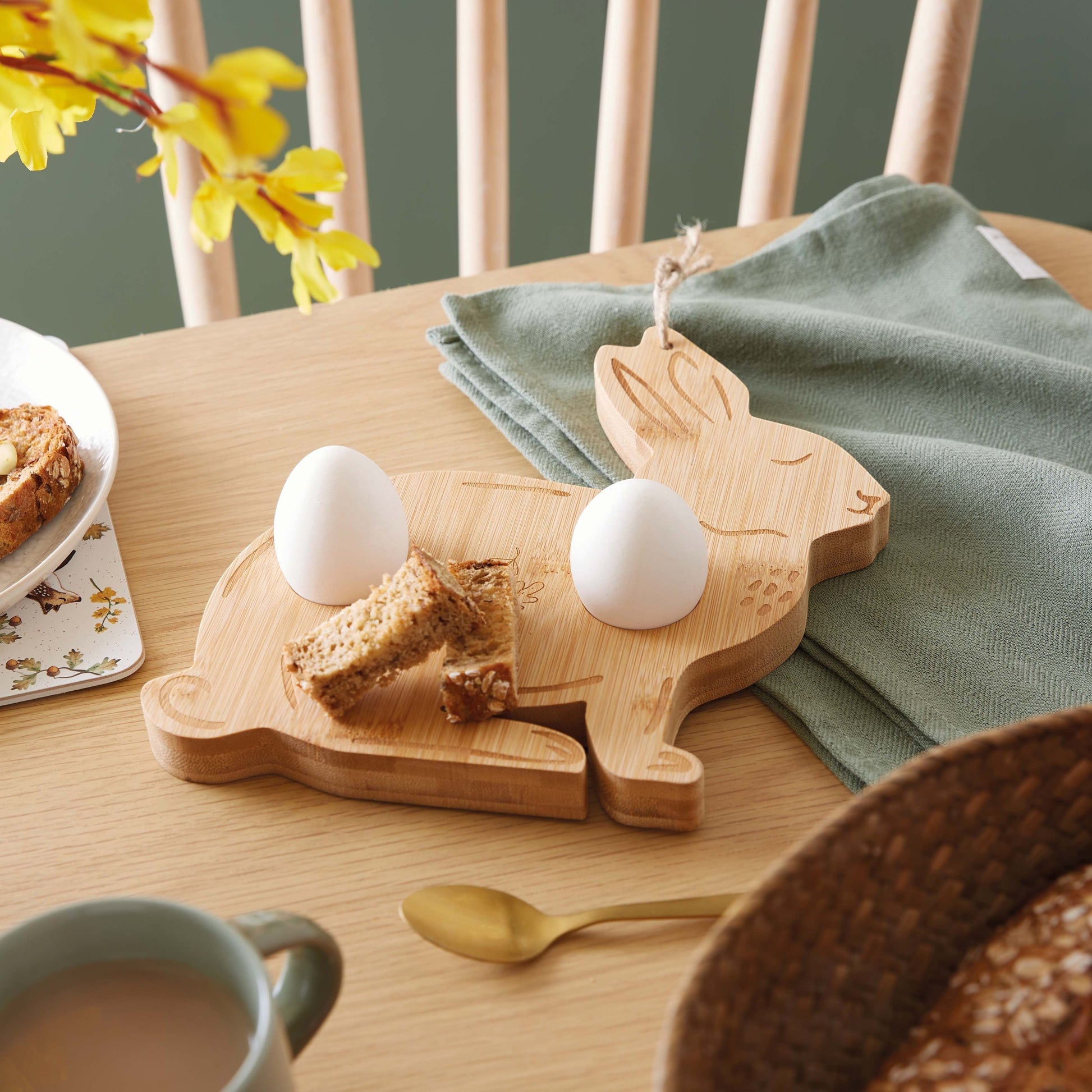 Cartco Cooksmart Forest Fable bamboo breakfast board shaped like a rabbit holding two boiled eggs and toast