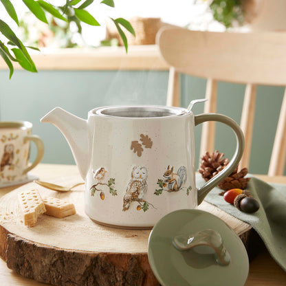 Cartco ceramic teapot with woodland owl and squirrel design, cream speckled finish, and sage green lid on wooden table.