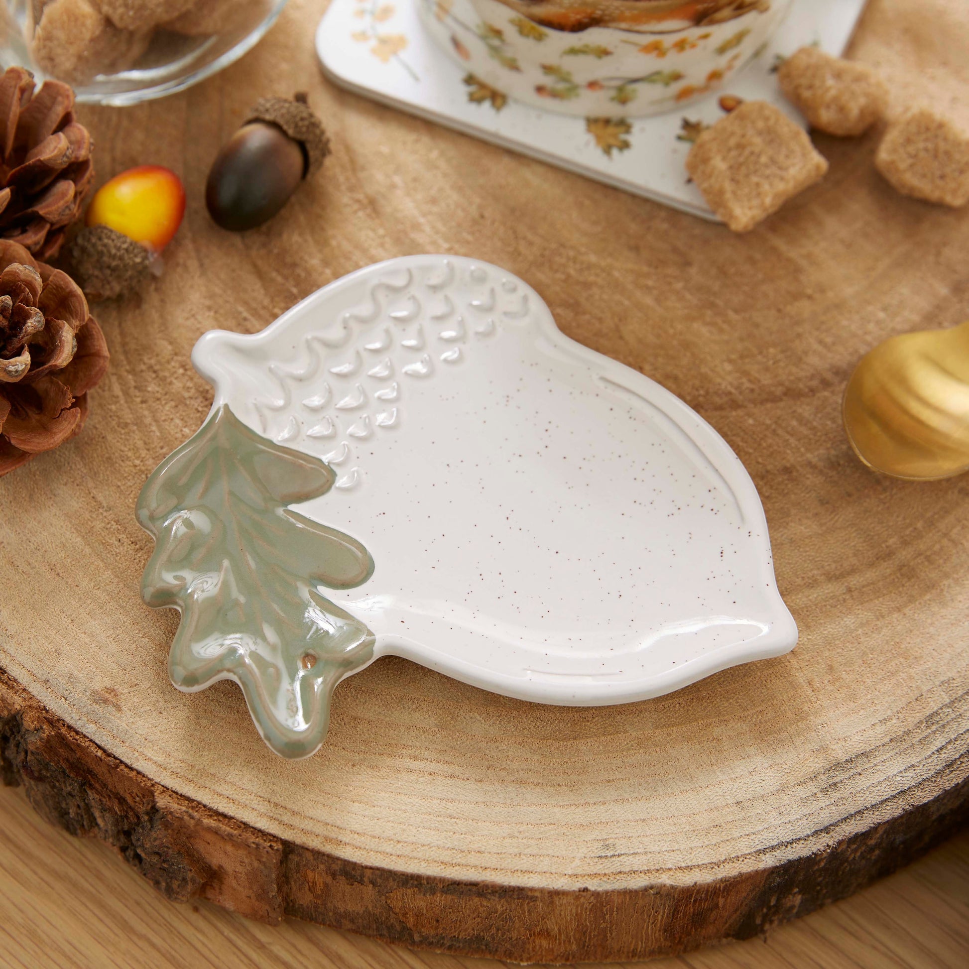 Cartco Cooksmart Forest Fable ceramic tea bag tidy shaped like a speckled acorn with a sage green oak leaf detail.