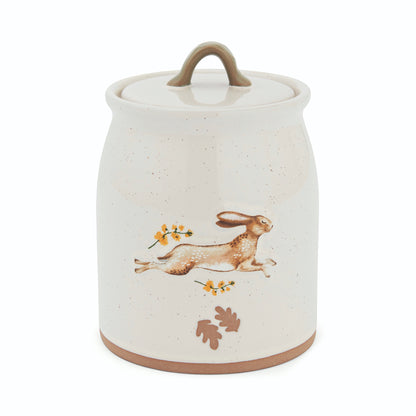 Cartco Cooksmart Forest Fable ceramic canister in cream with a running hare, golden flowers, and sage green loop handle.