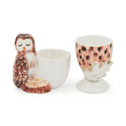 Cartco set of two ceramic egg cups featuring a sculpted owl and a textured acorn design for woodland-themed dining.