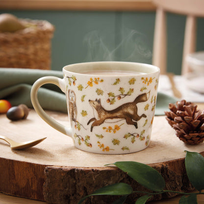 Cartco Cooksmart Forest Fable ceramic mug with fox and hare woodland print, sage green handle, and steaming drink.