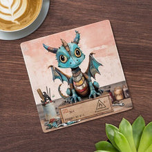 Cartco ceramic coaster featuring a blue patchwork Scrap Dragon illustration with cork backing on a wooden table.